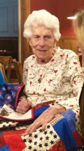 Marie Duggins receives a Quilt of Valor from the Dream Quilters of Westerly, Rhode Island. The label contained a photograph of her and her younger brother in their Navy uniforms.